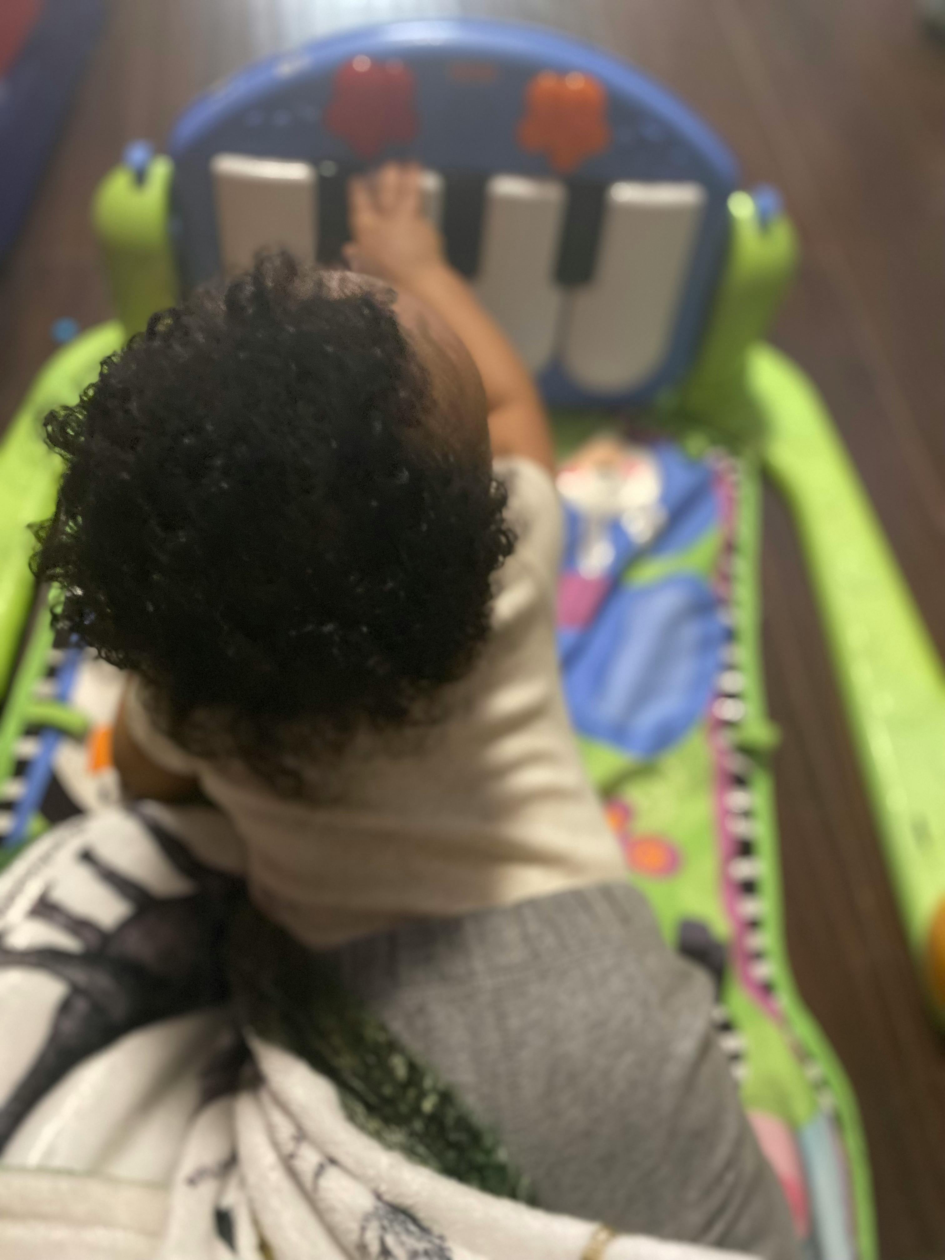 Child playing with a toy piano on a playmat