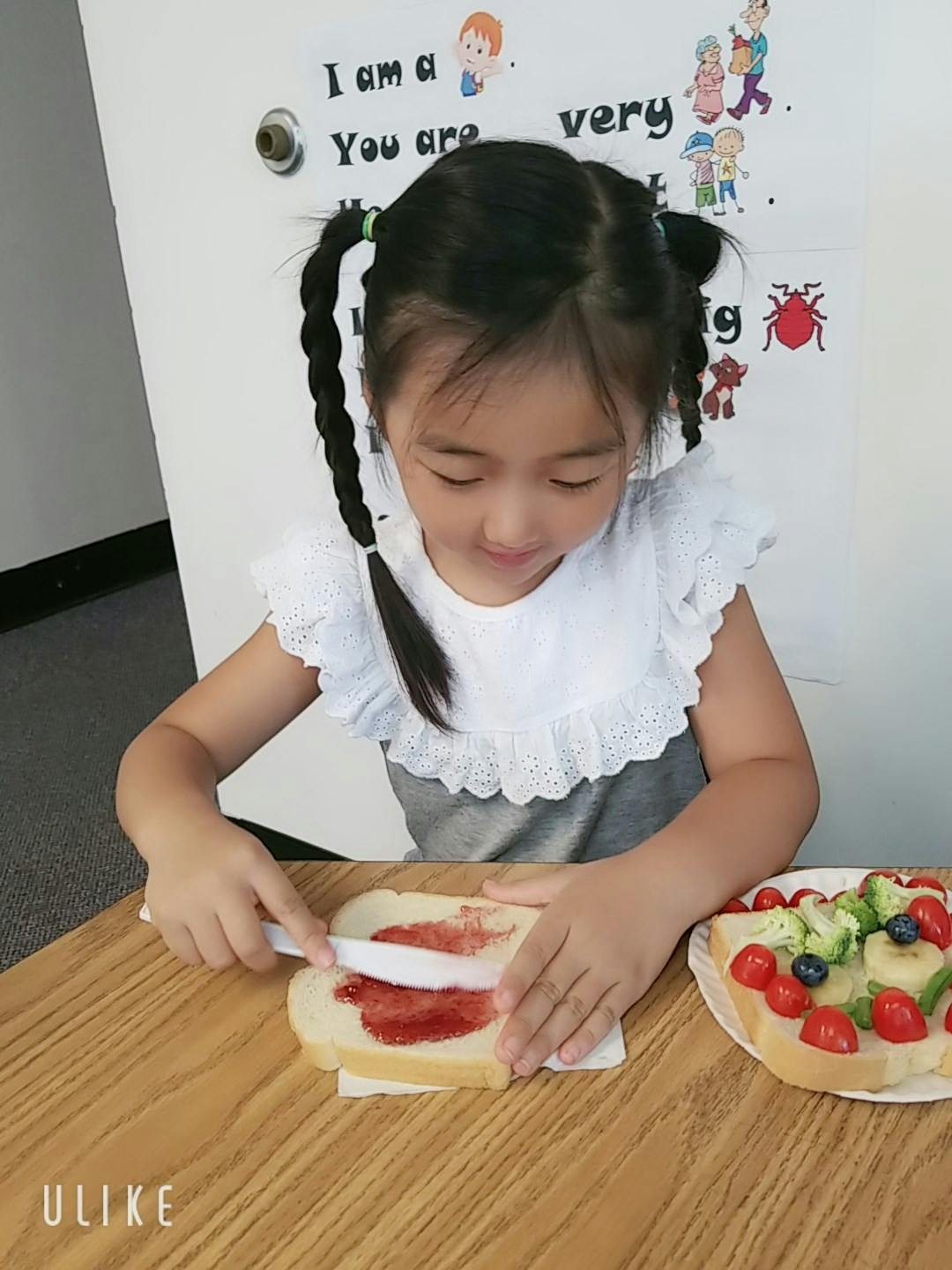 Child spreading jam on bread