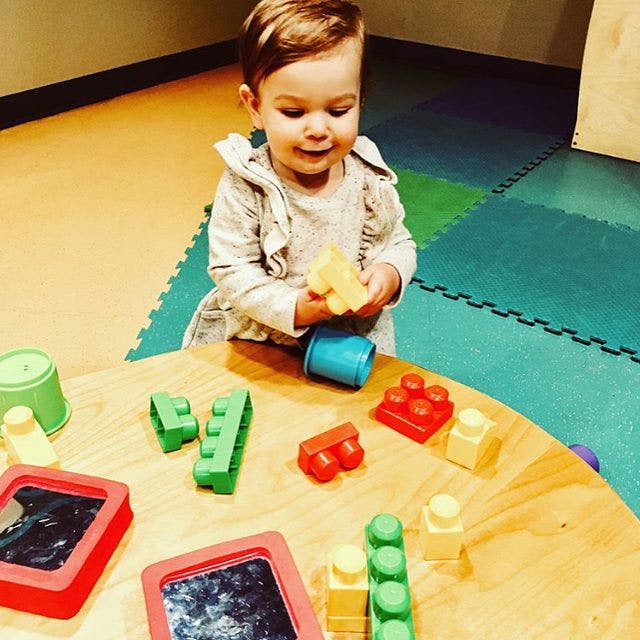 Child playing with building blocks at a table
