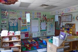 Classroom with colorful rug and student artwork on walls