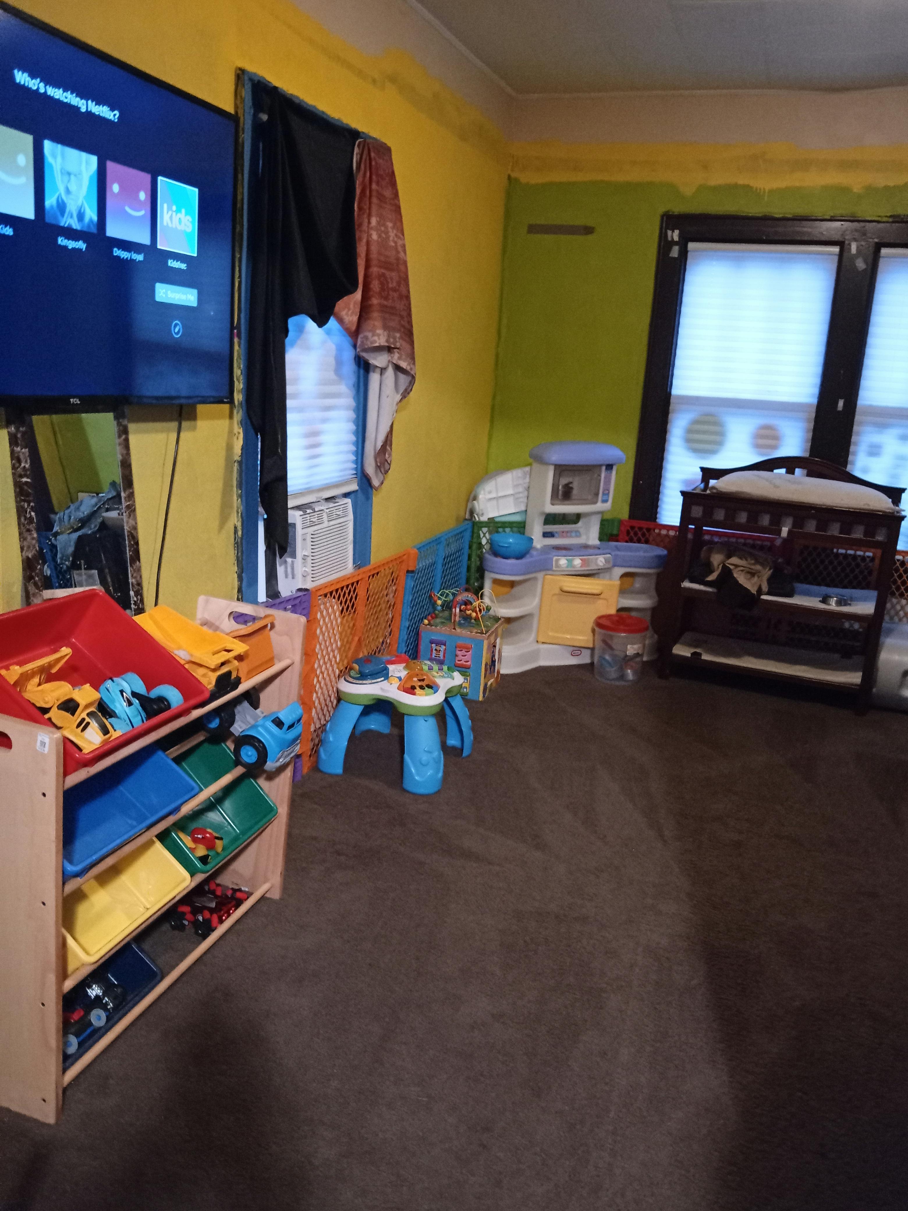 Playroom with toy storage, play kitchen, and television