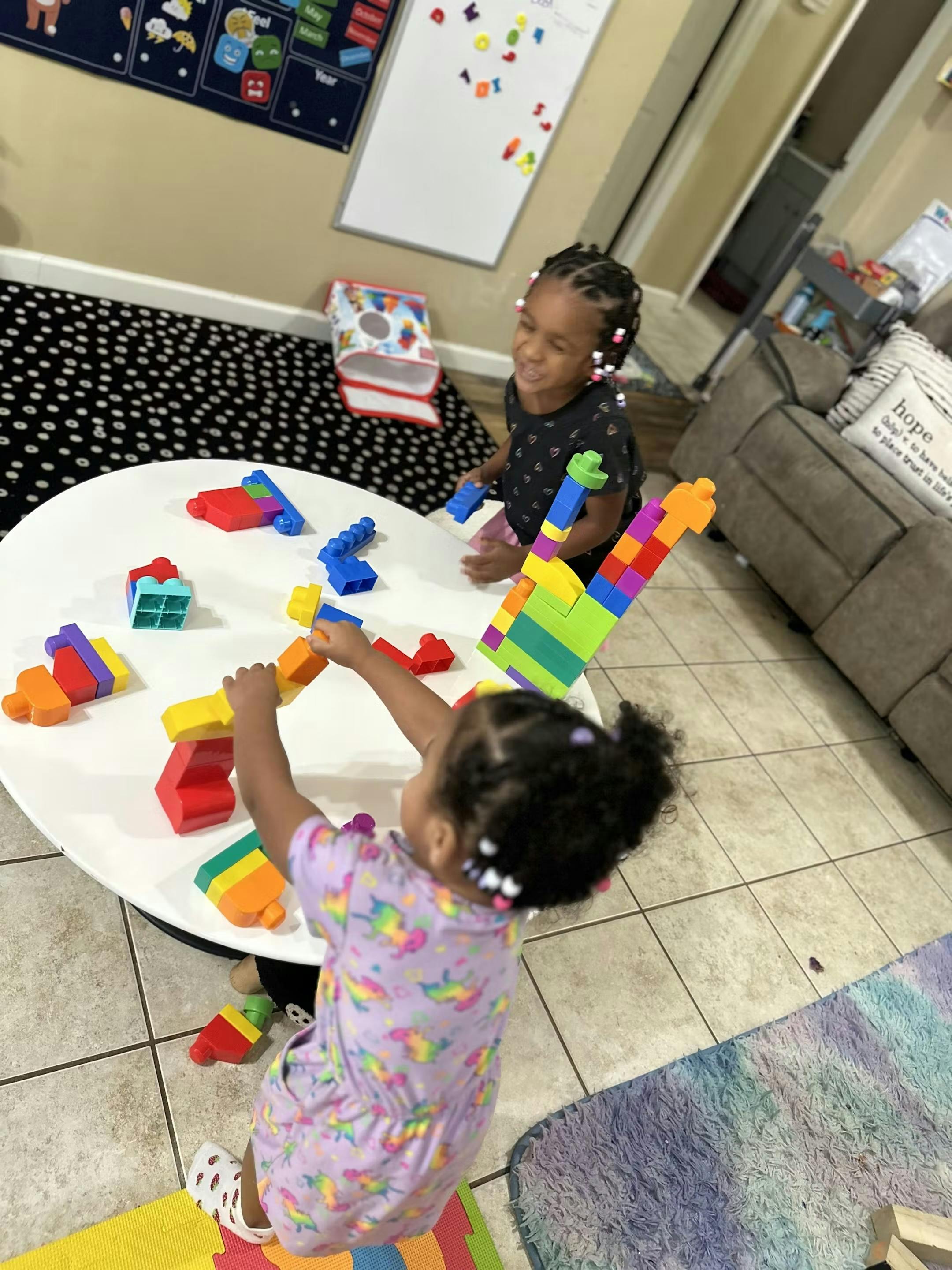 Two children playing with colorful building blocks at a table