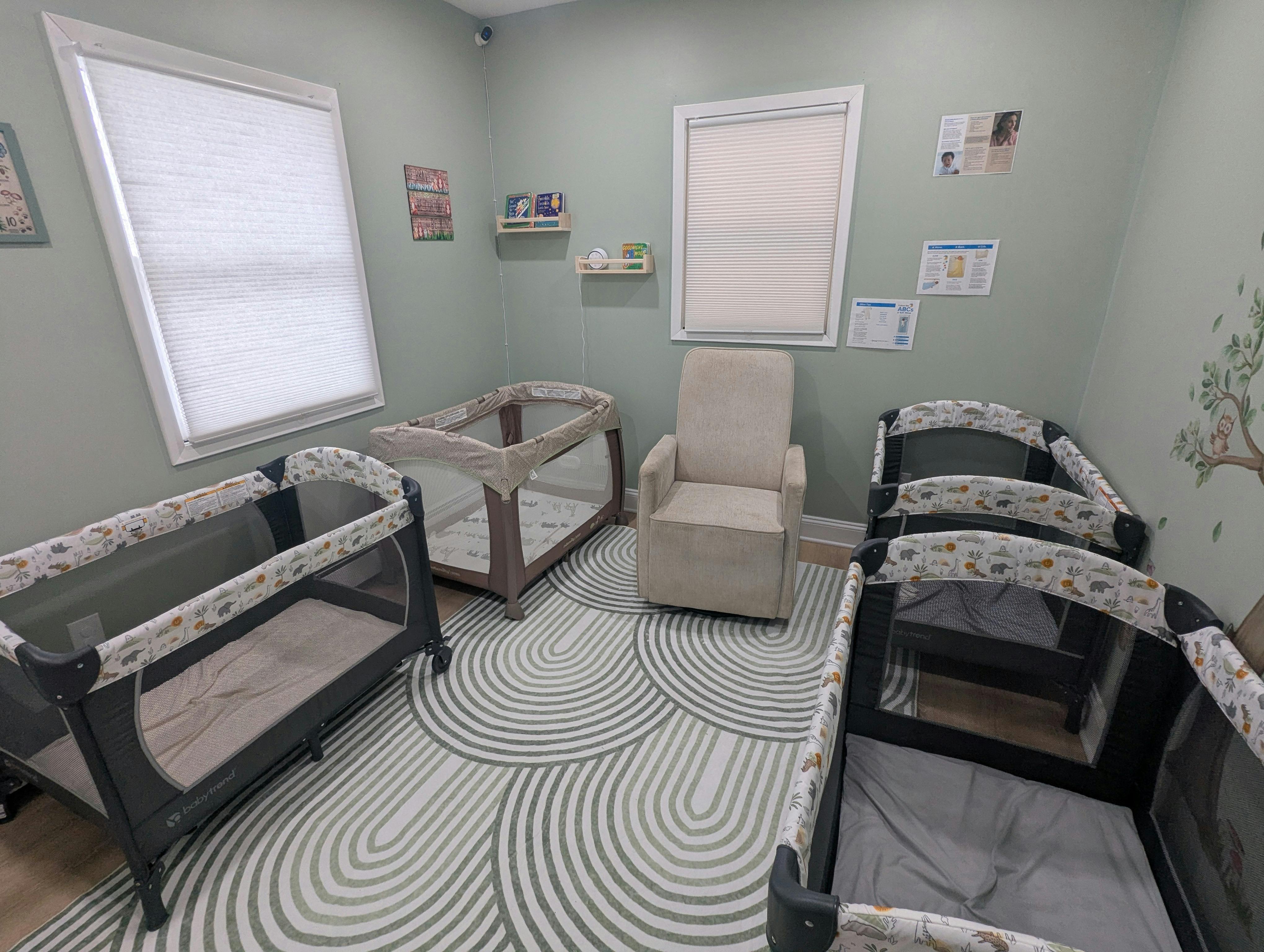 Room with several baby cribs, a changing station, and a rocking chair