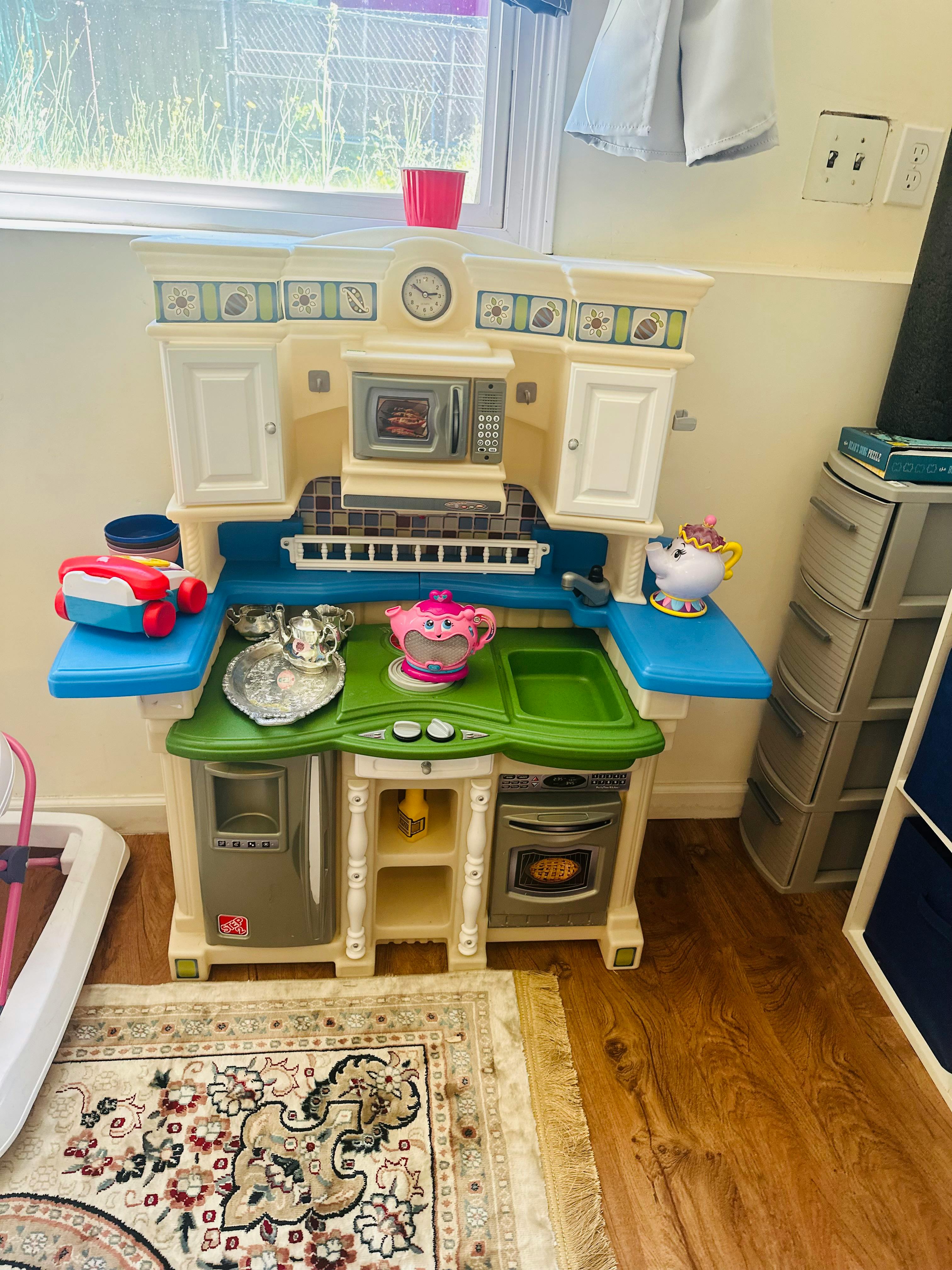 Child's play kitchen with toy dishes and food