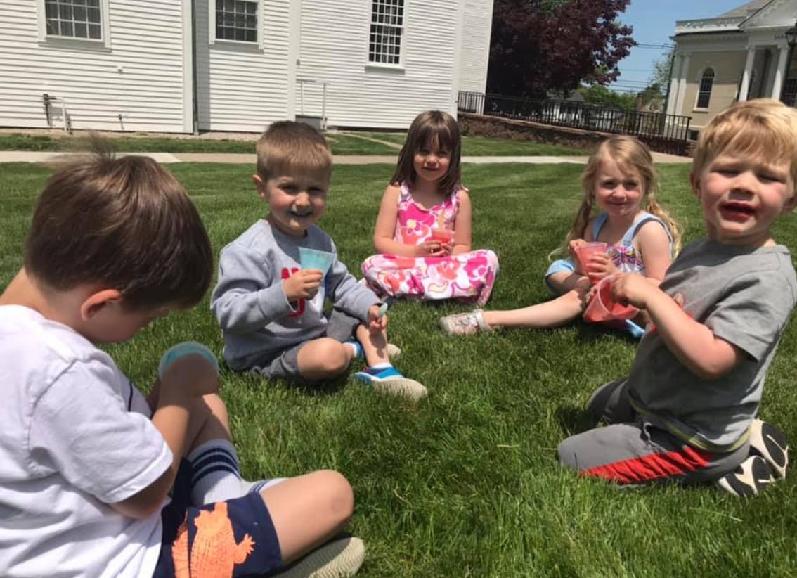 Group of children sitting on grass outdoors