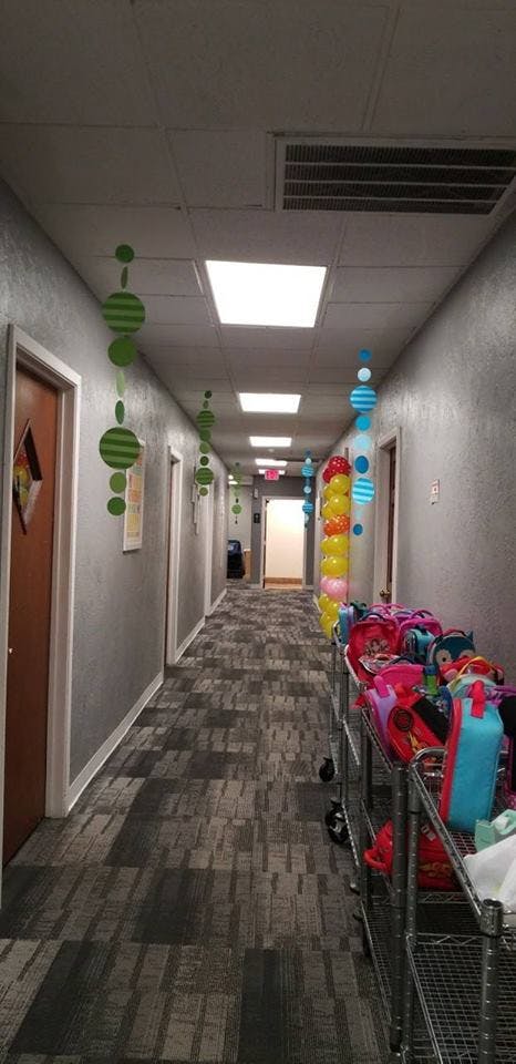 Hallway decorated with hanging ornaments and balloons, with carts of bags