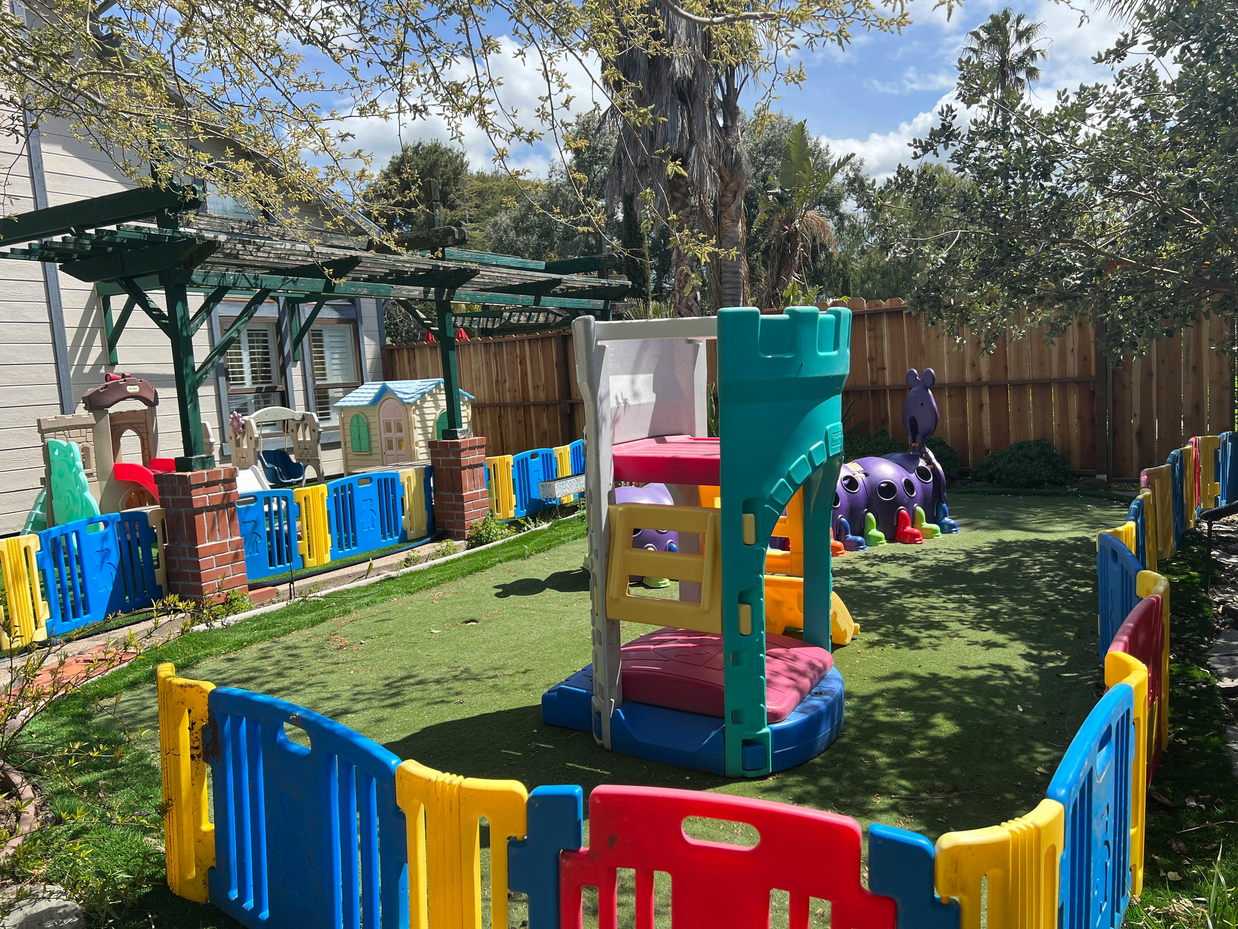 Outdoor playground with colorful play structures and fences