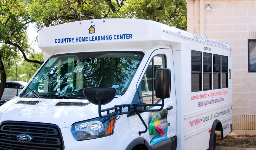White bus with "Country Home Learning Center" on the front