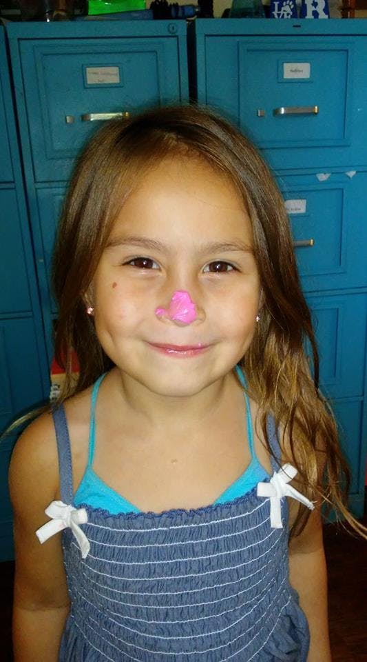 Child with pink paint on their nose