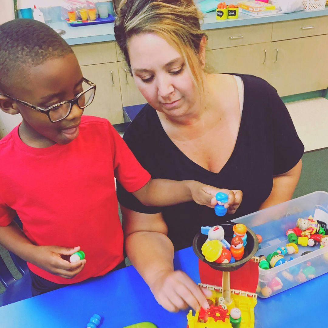 Adult and child playing with toys at a table