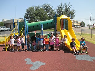Children standing and sitting on a playground