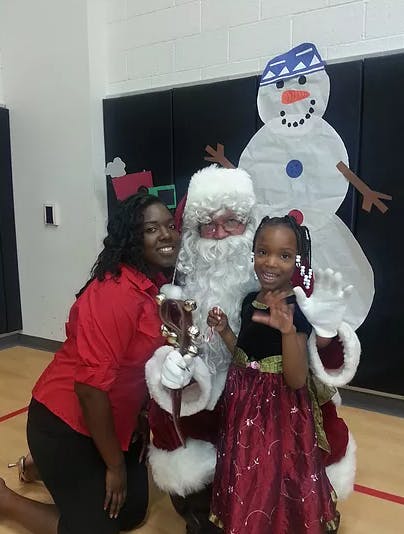 Person and child with a person dressed as Santa Claus
