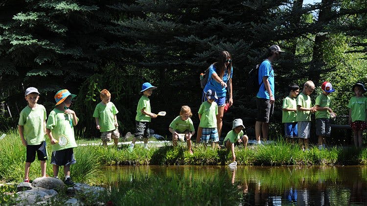Children and adults by a pond