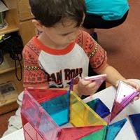 Child playing with colorful magnetic tiles