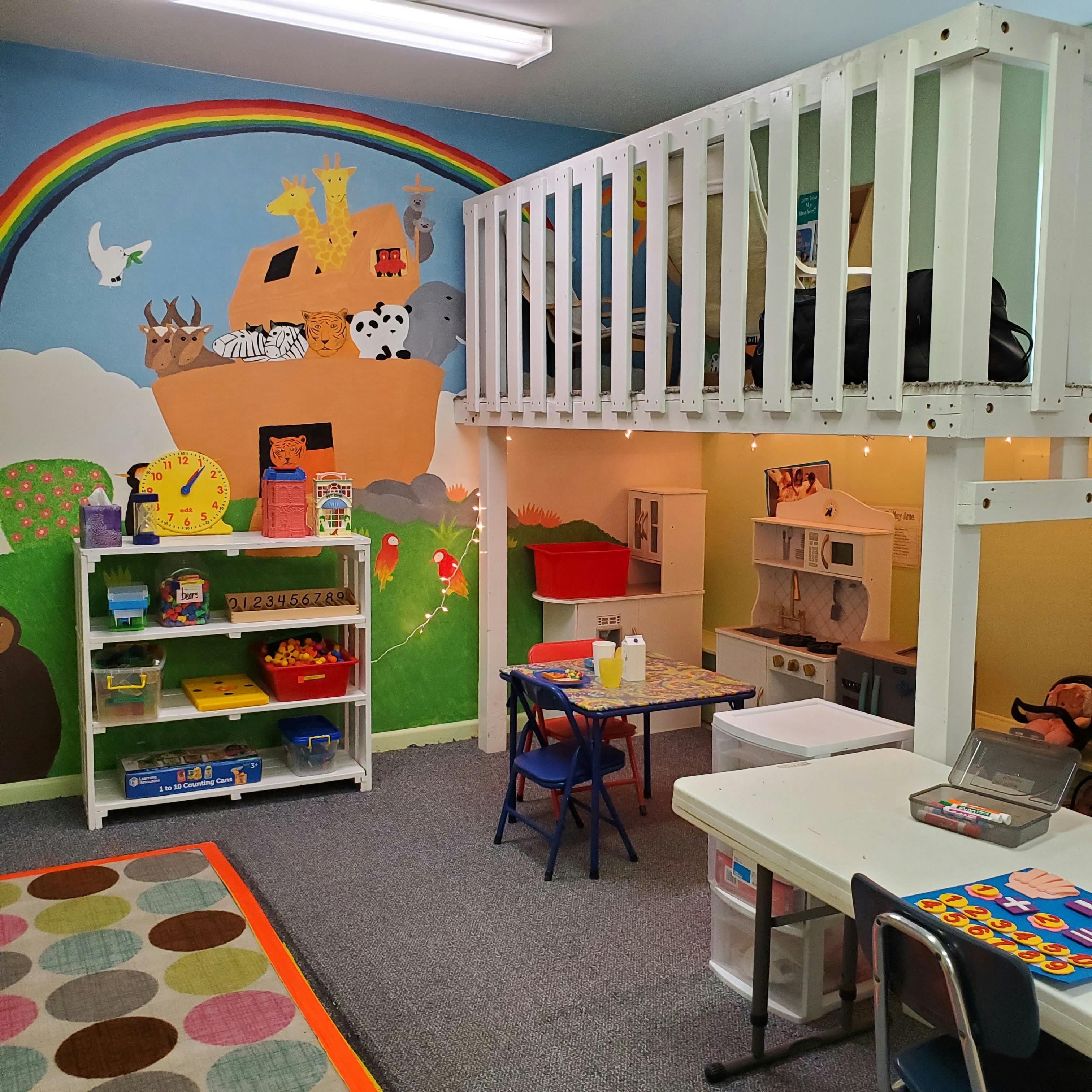 Playroom with a loft, mural, and small tables