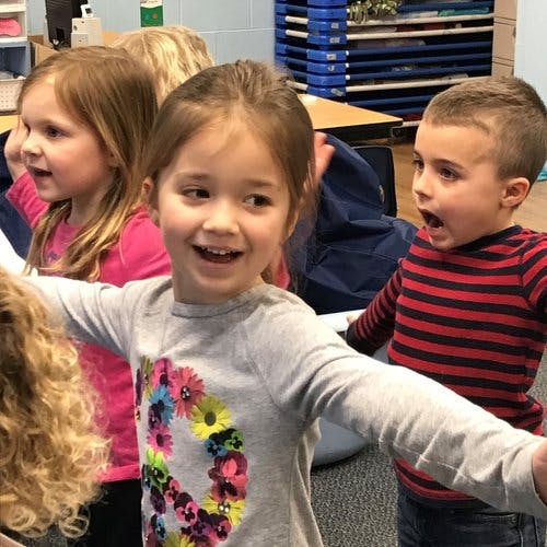 Three children looking forward, one with mouth open