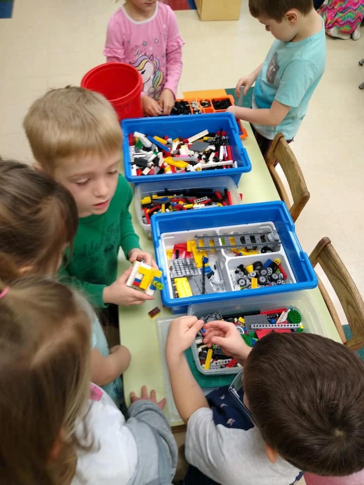 Children playing with building blocks at a table
