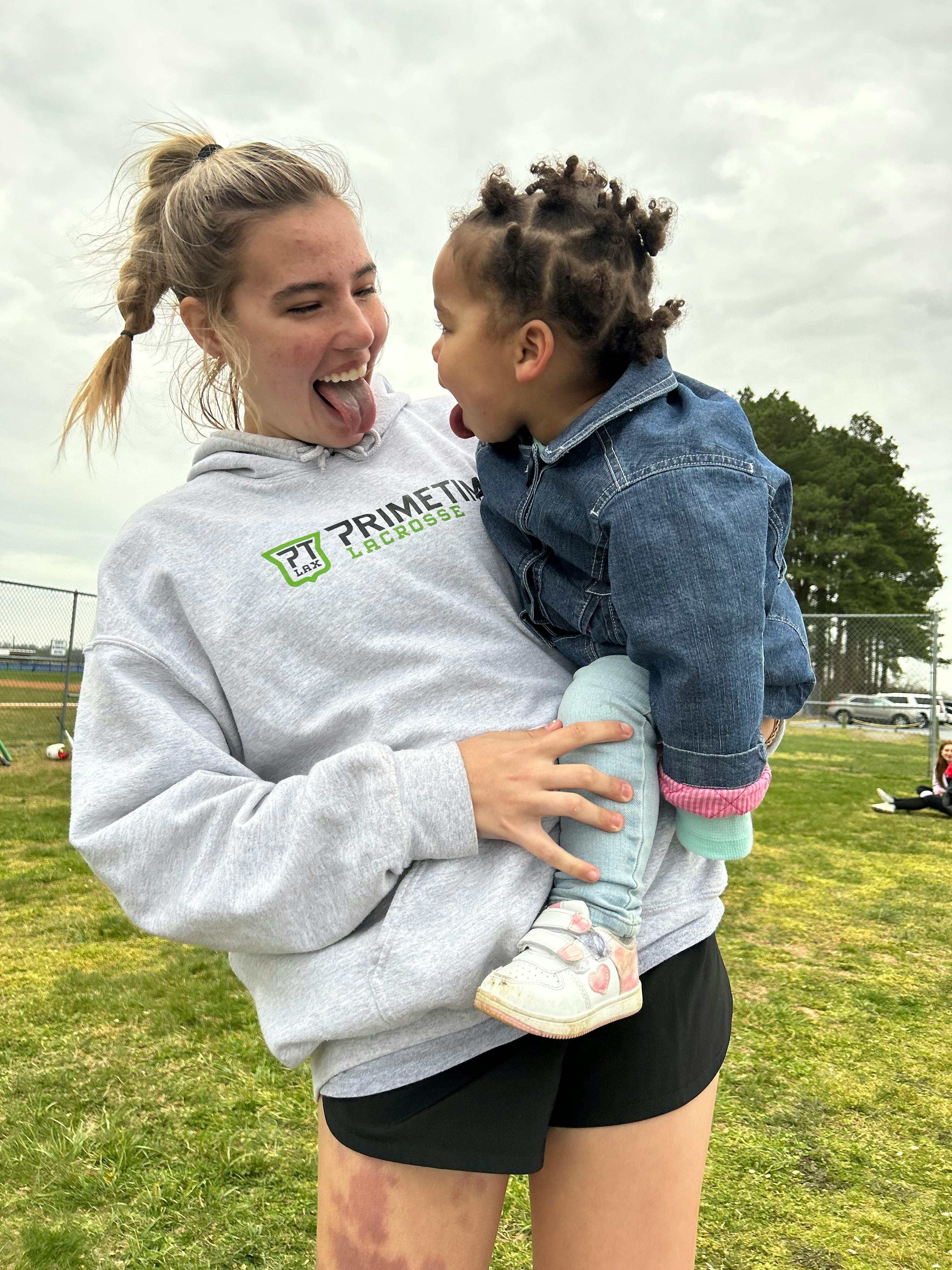 Person holding a child, both sticking out their tongues