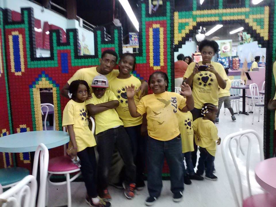 Group of people and children in yellow shirts posing