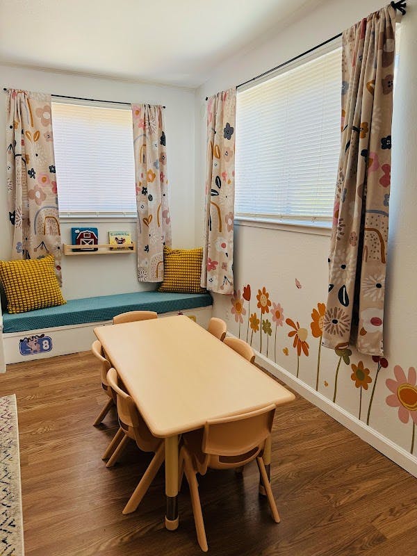 Children's classroom with a small table and chairs, and a window seat