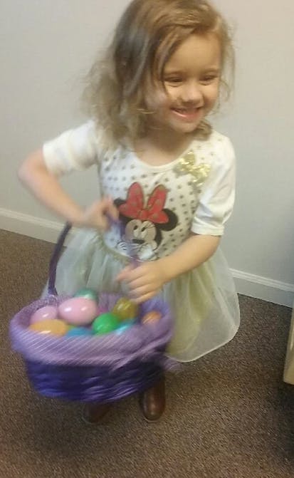 Child holding a basket of colorful eggs