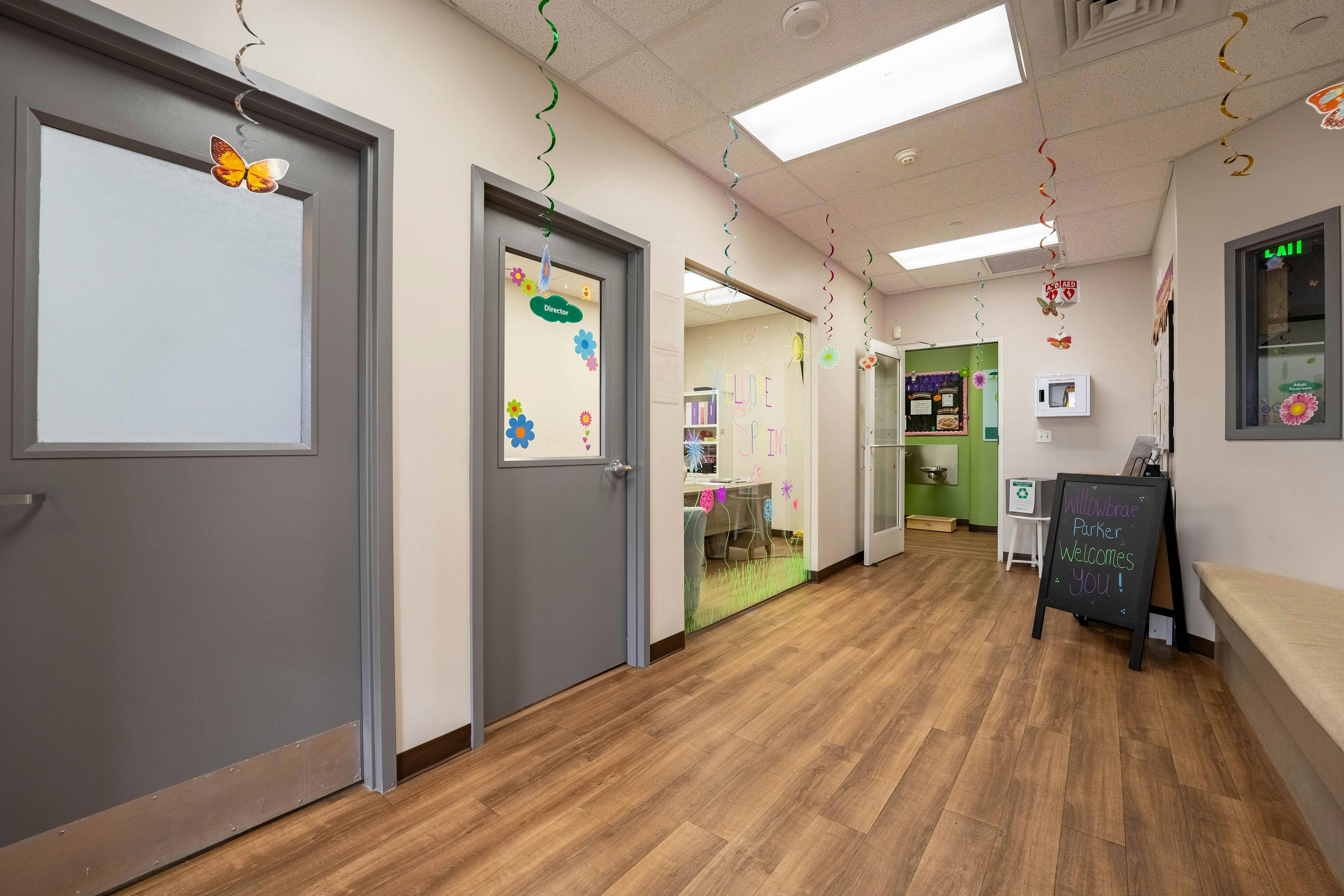 Hallway in a facility with doors, colorful decorations, and a welcome sign