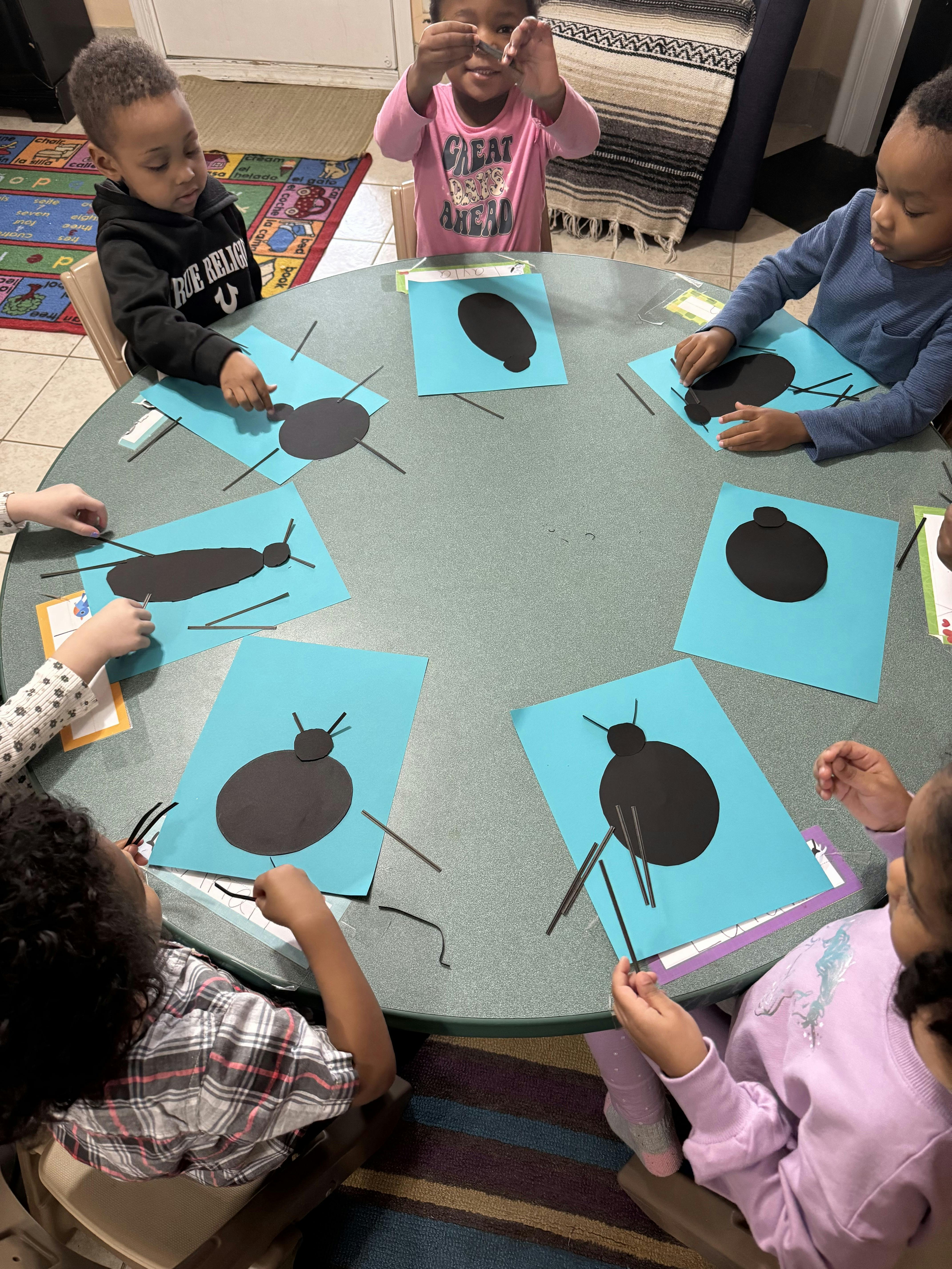Children making bug crafts at a table