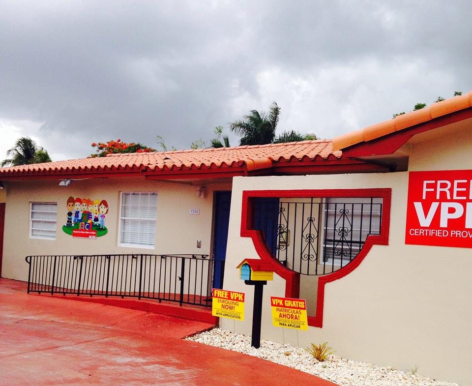 Building exterior with red roof and mural of children playing