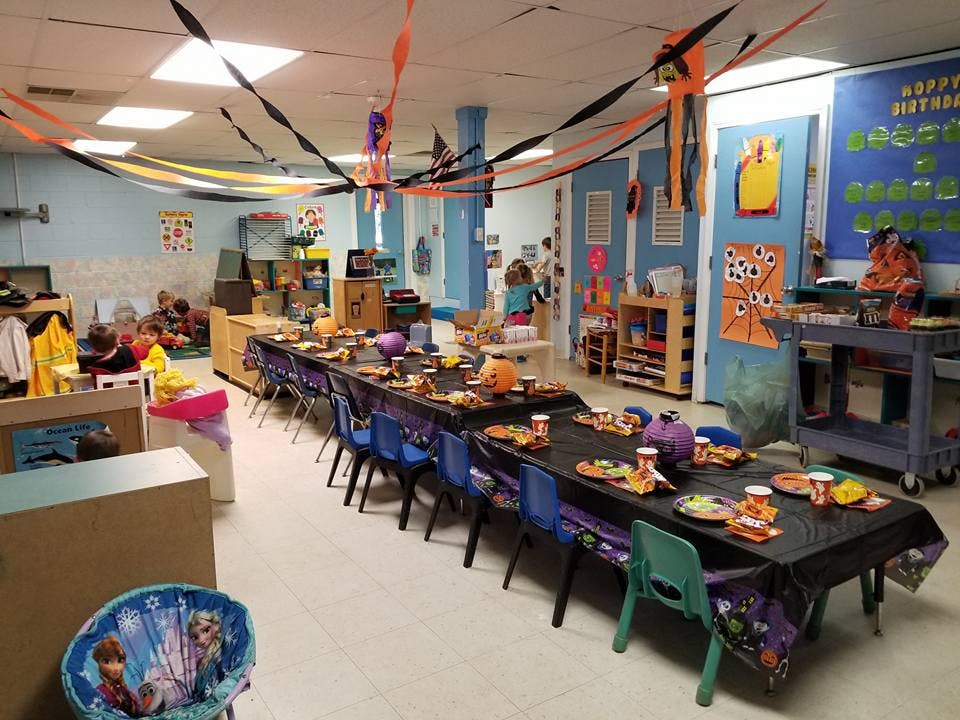 Classroom decorated for a party with long tables set with plates and chairs