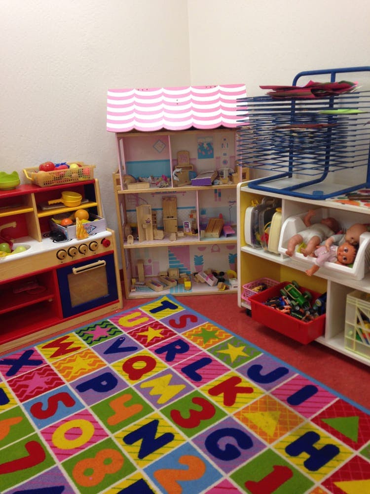 Playroom with a toy kitchen, dollhouse, and alphabet rug