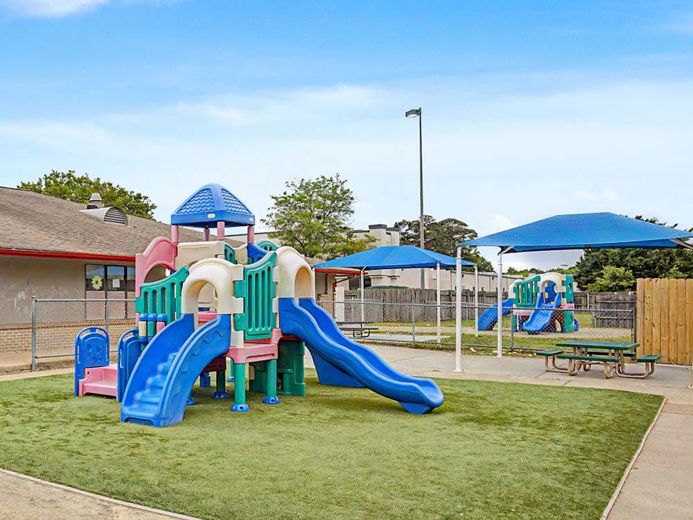 Colorful outdoor playground with slides and artificial turf