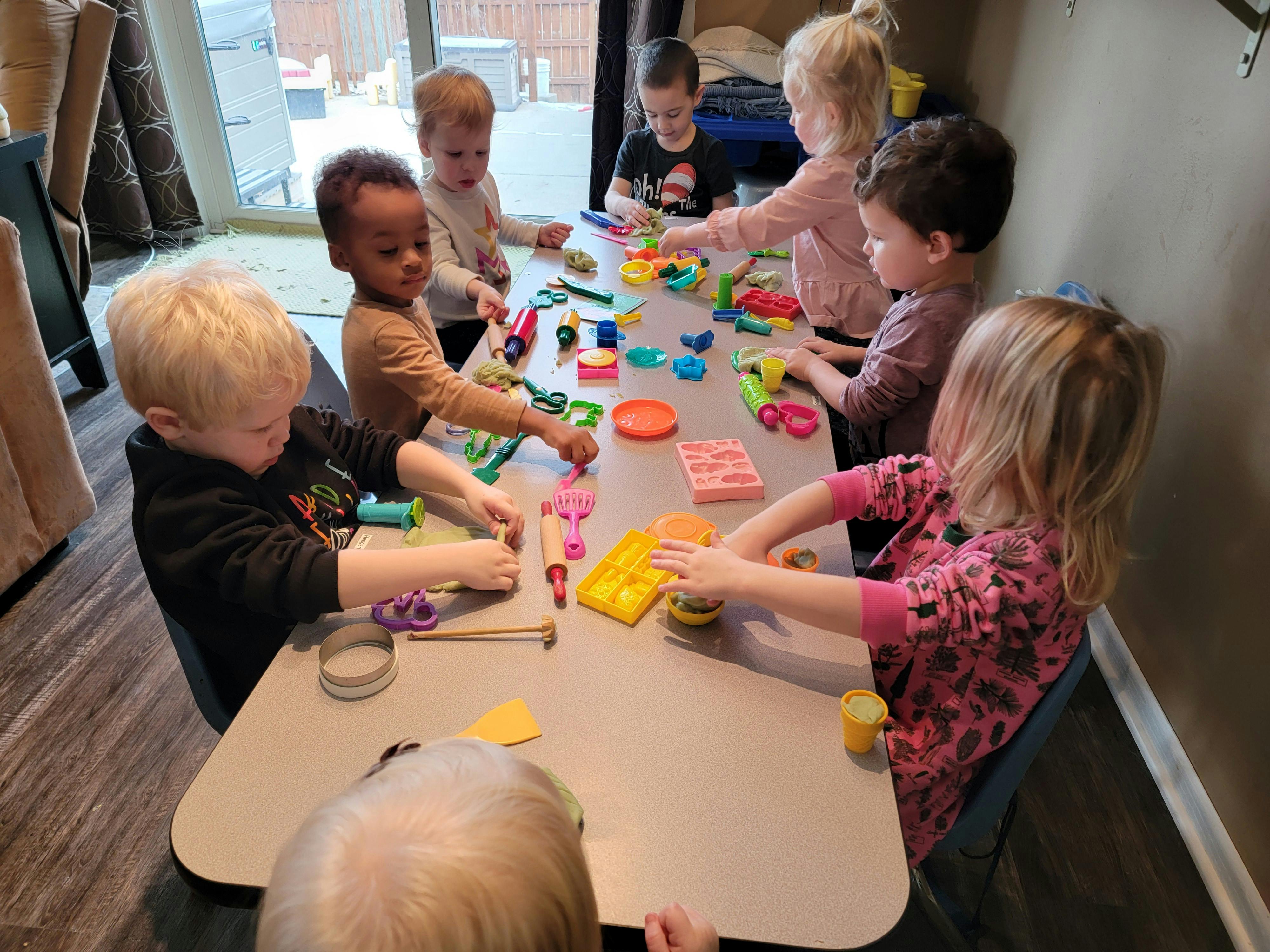Children playing with colorful toys at a table
