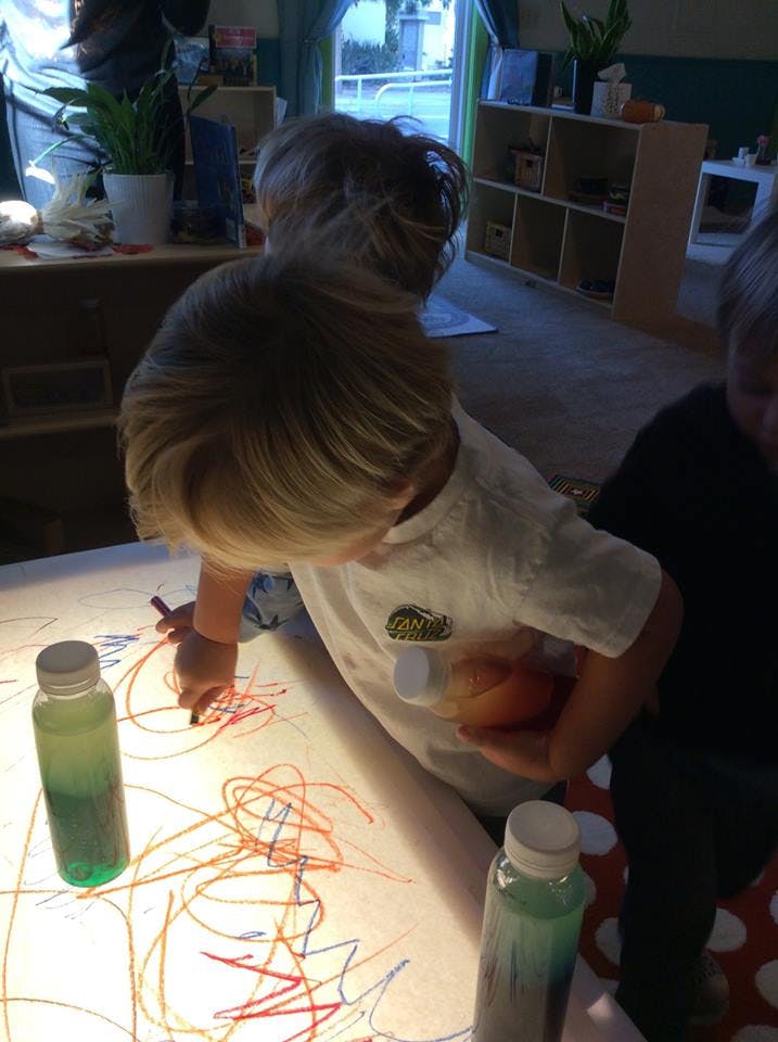 Child drawing on a large piece of paper with markers