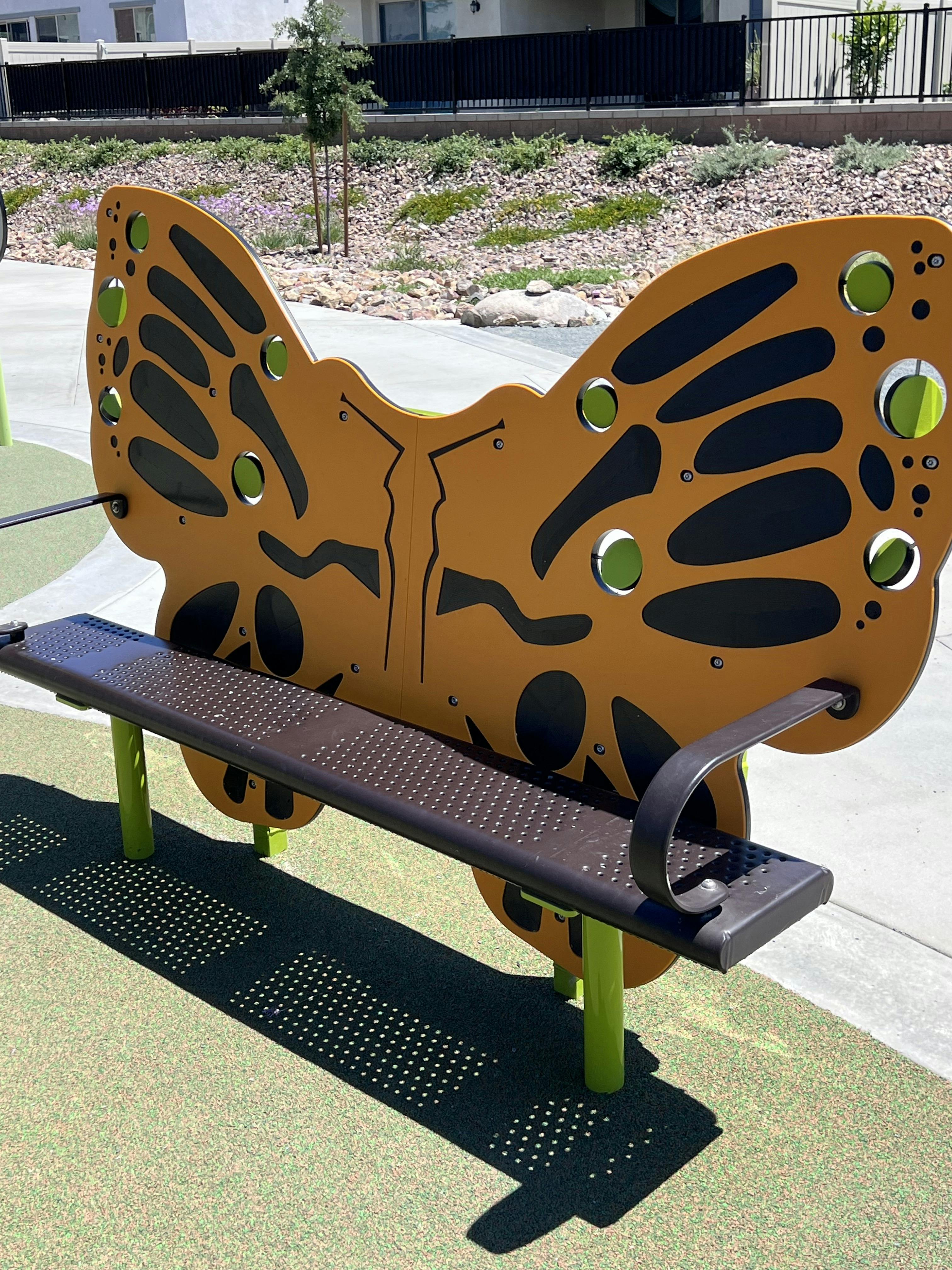 A park bench with a butterfly-shaped backrest
