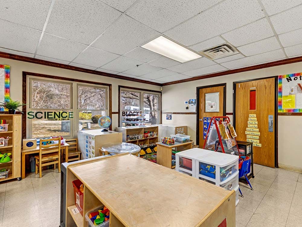 An empty classroom with various learning stations and small tables