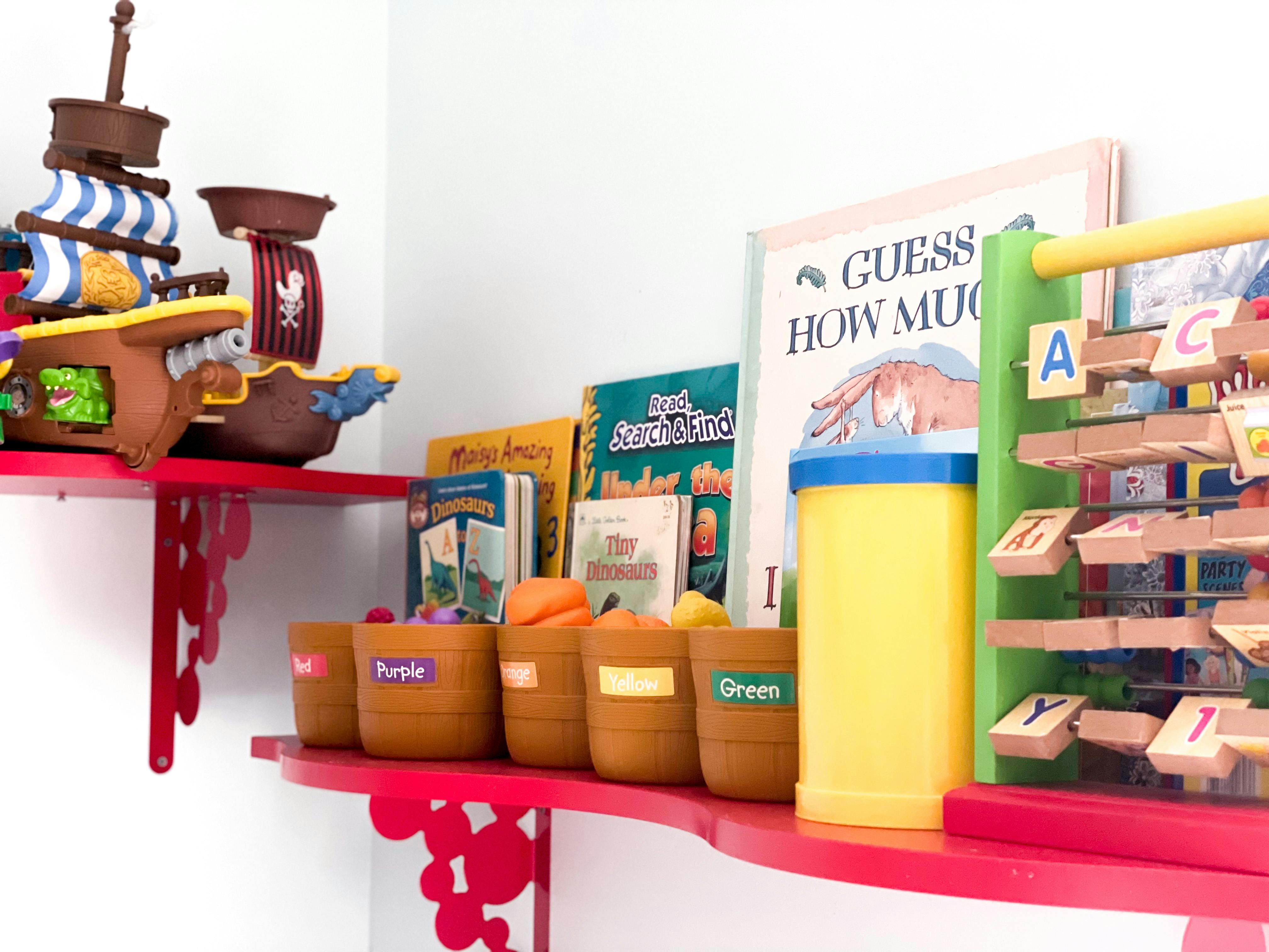 Children's toys and books on red shelves