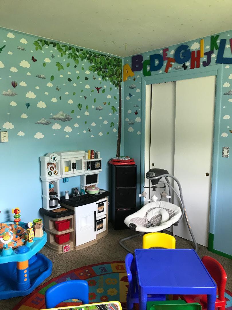 Child's playroom with a toy kitchen, baby swing, and small table and chairs