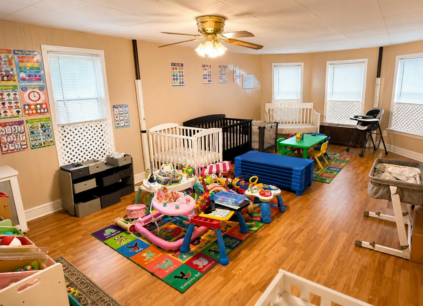 Child care room with play mats, baby furniture, and colorful educational toys