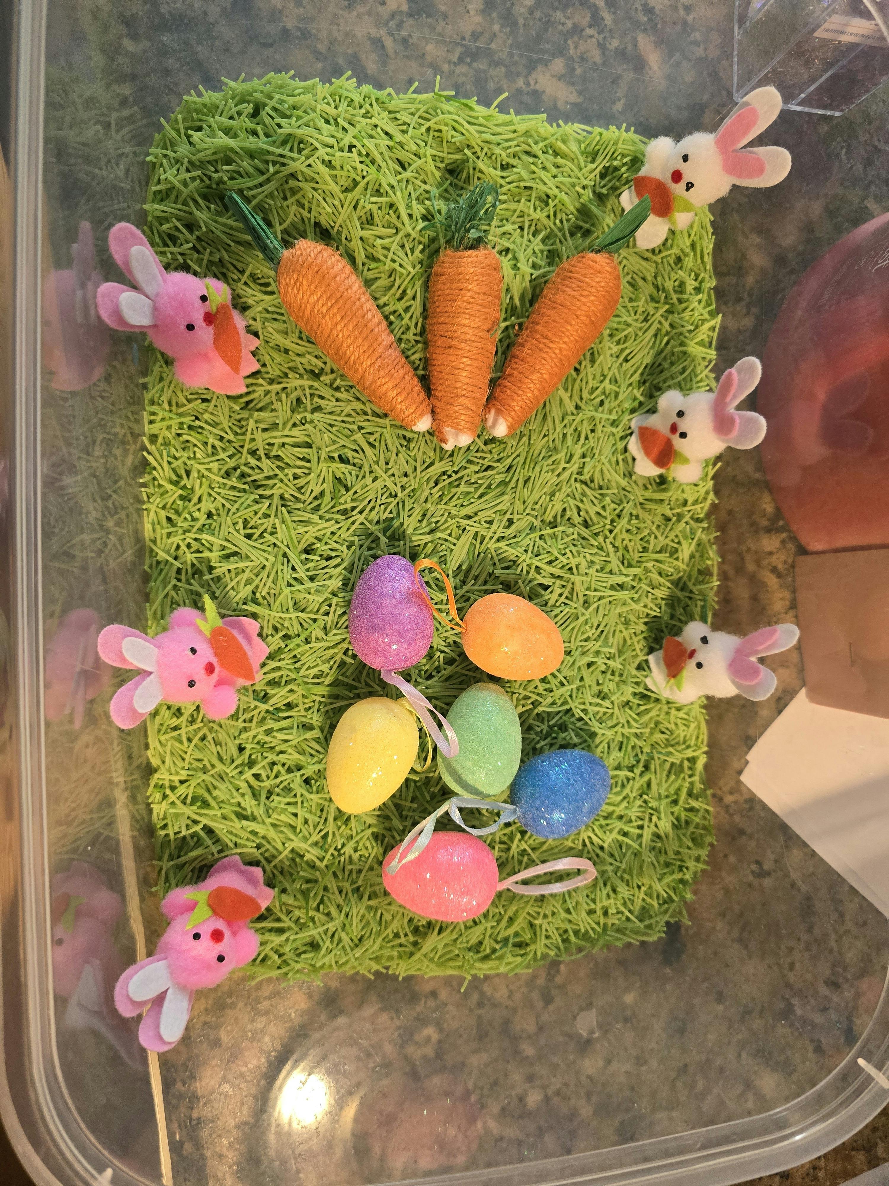 Decorative carrots, bunnies, and colorful eggs on green Easter grass