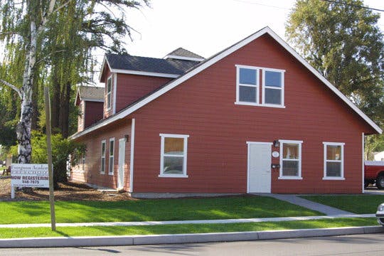 Red house with white trim and a white door