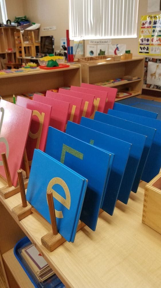 Alphabet letter boards on a shelf in a classroom