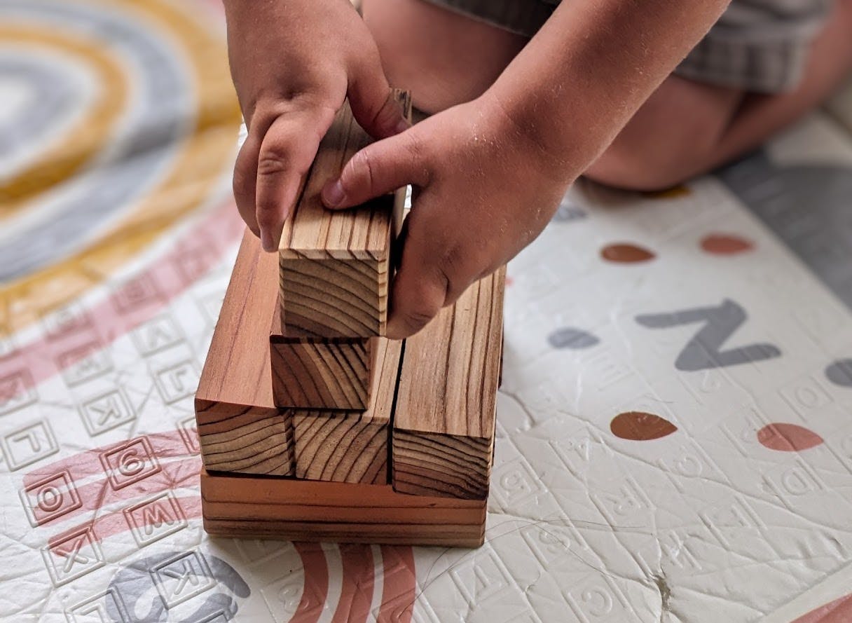 Child's hands stacking wooden blocks