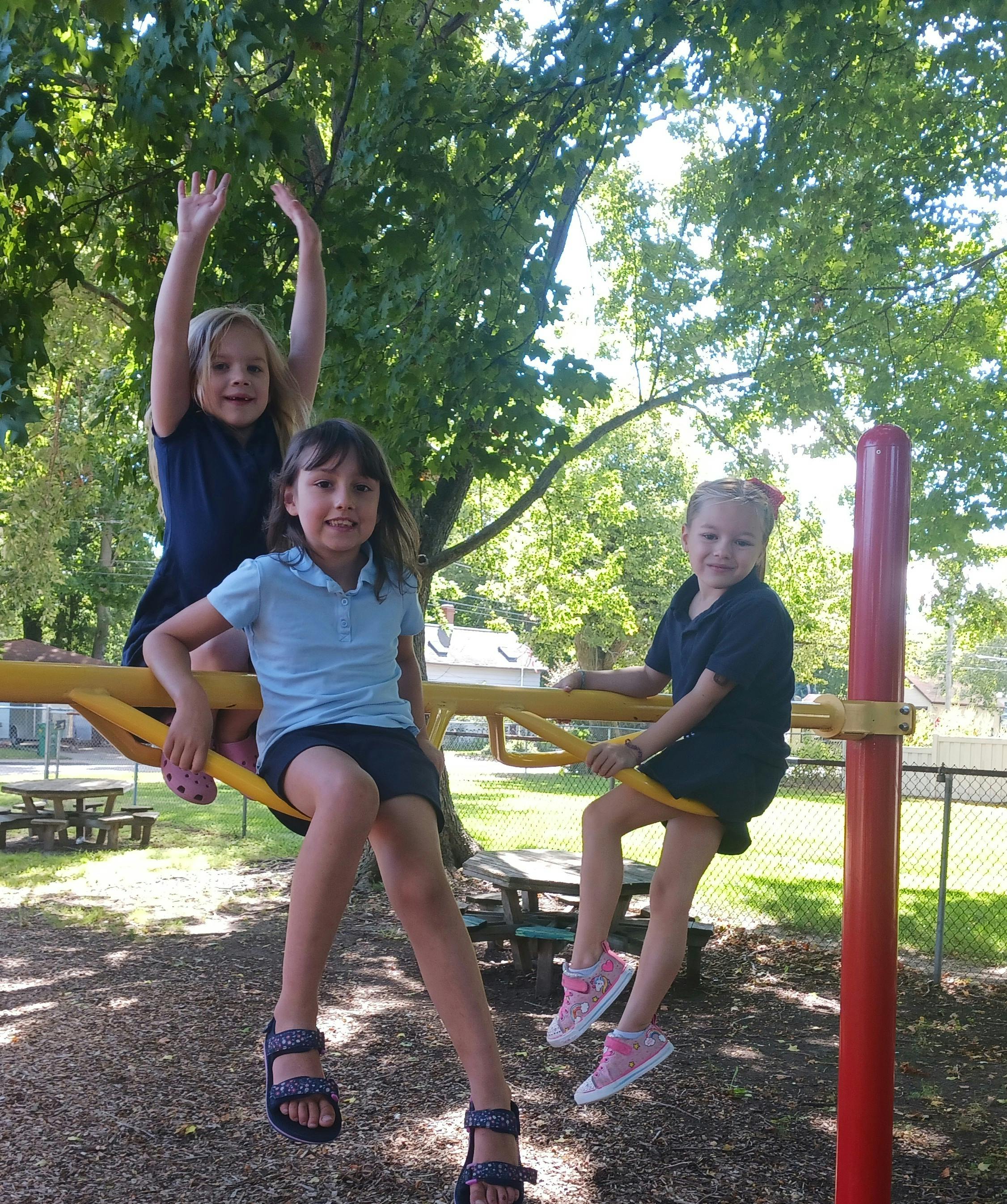 Three children on playground equipment