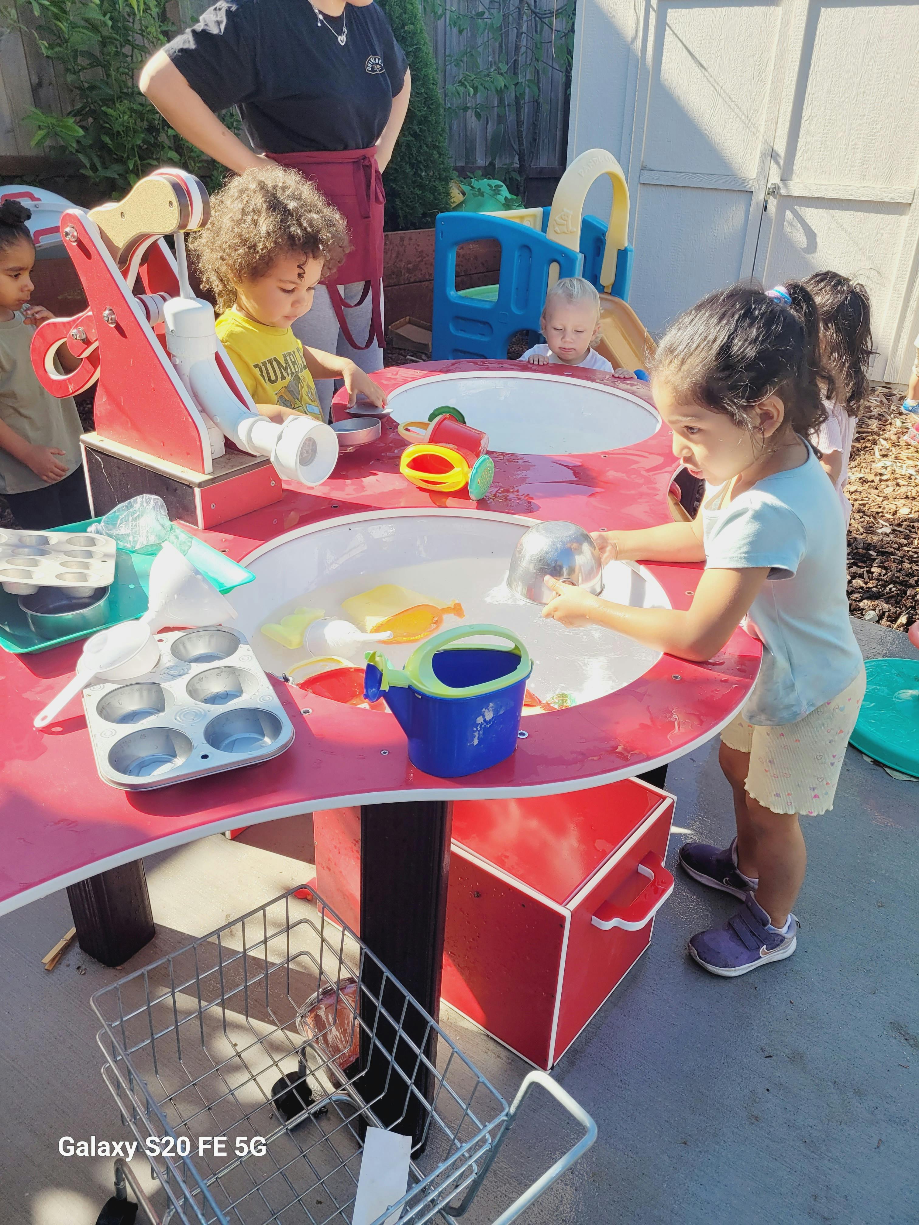 Children playing at a water table outdoors