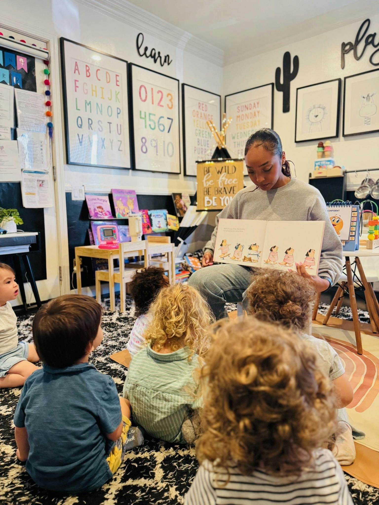 Person reading a book to children in a classroom