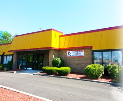 Building with yellow facade and red trim, sign reads "Building Blocks Academy"