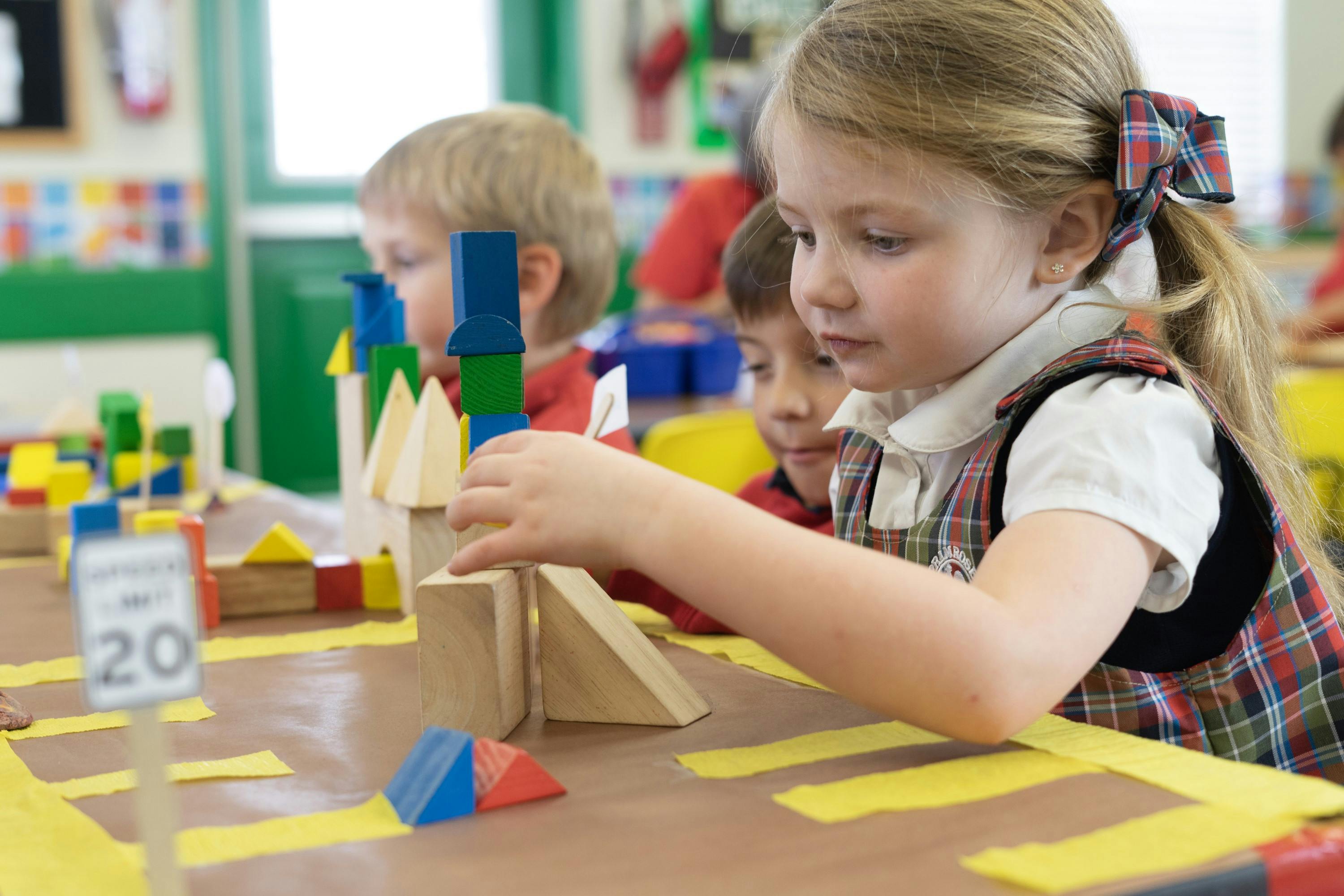 Child playing with wooden blocks in a classroom