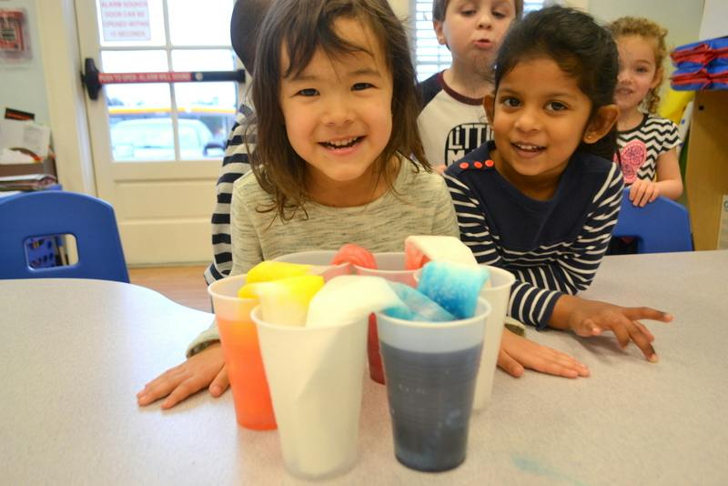 Two children at a table with colorful cups