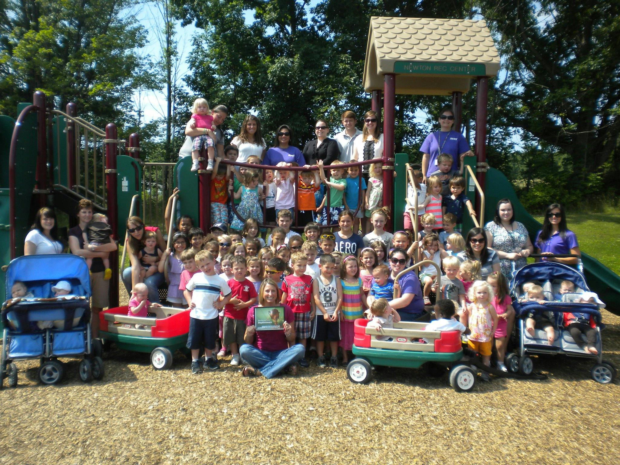 Large group of adults and children posing on a playground