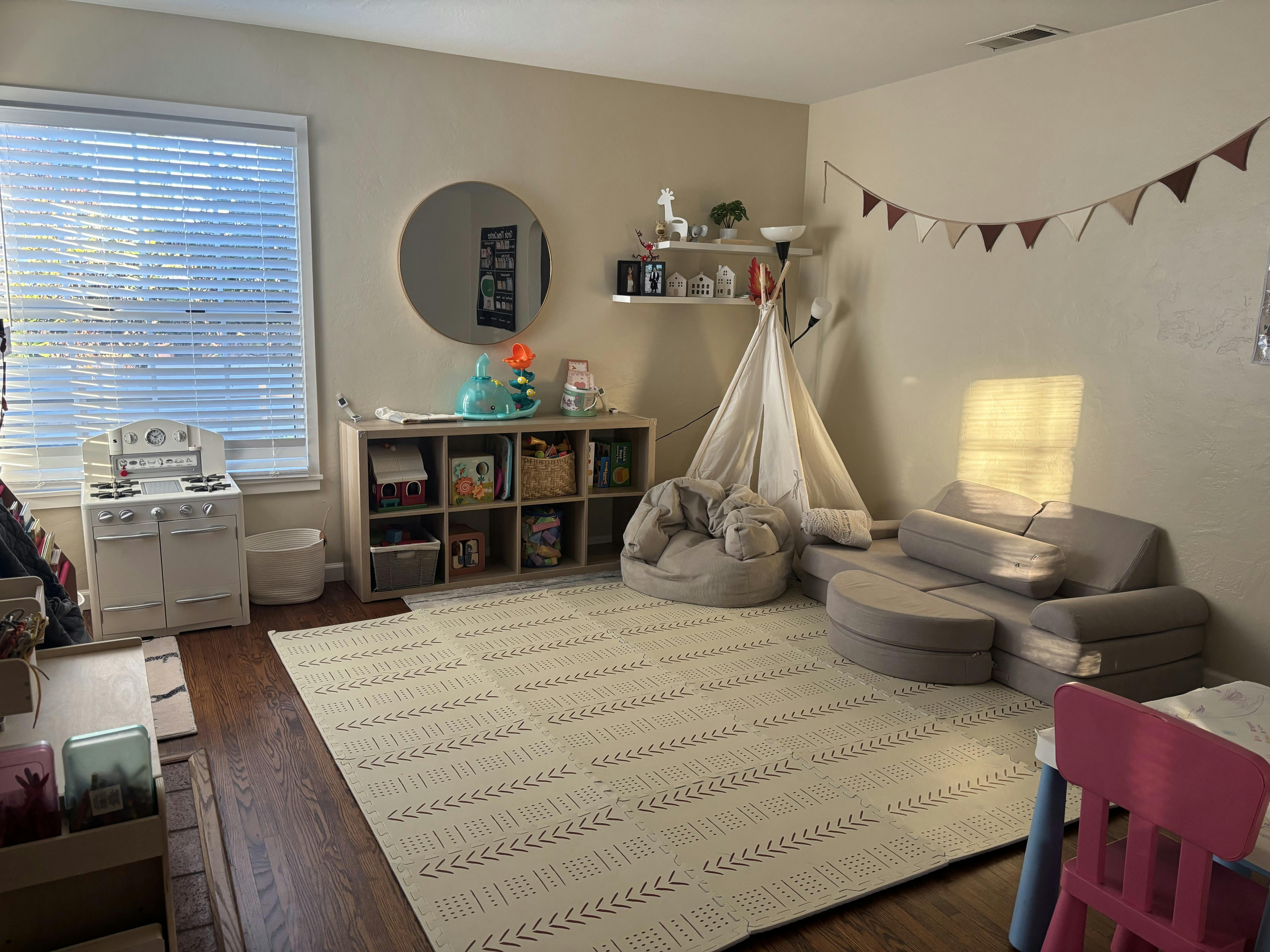 Child's playroom with teepee, sectional, bean bag, and toy kitchen